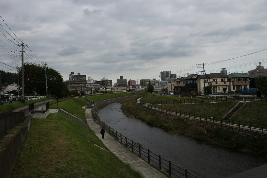 住宅街を流れる川が手前から奥へカーブして続く風景