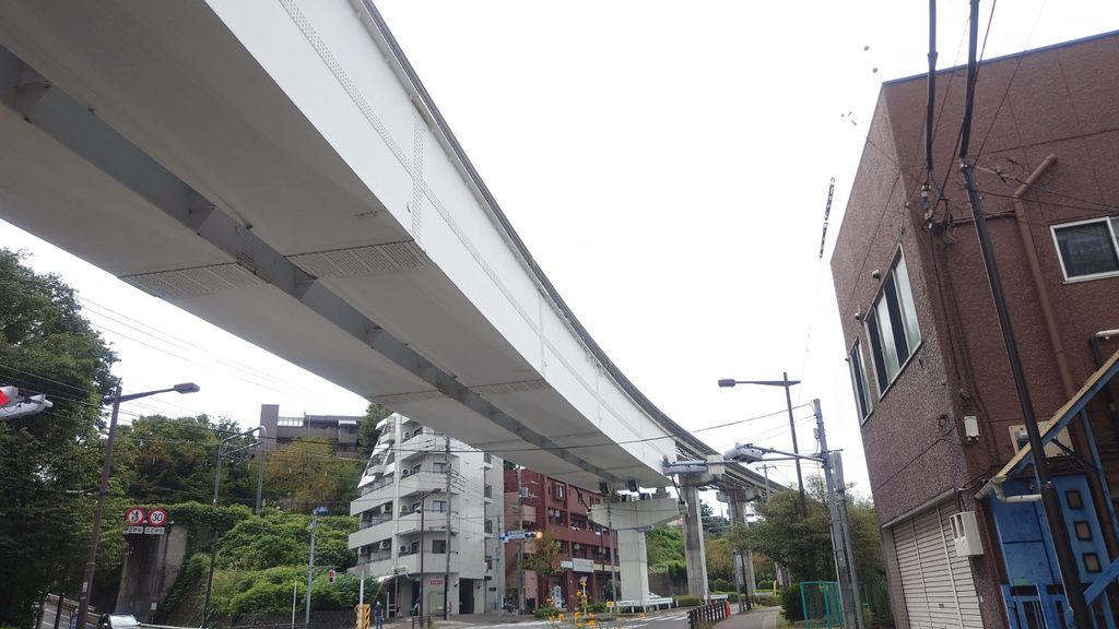 高架を見上げる構図で周囲に建物や電線、信号などが写った風景